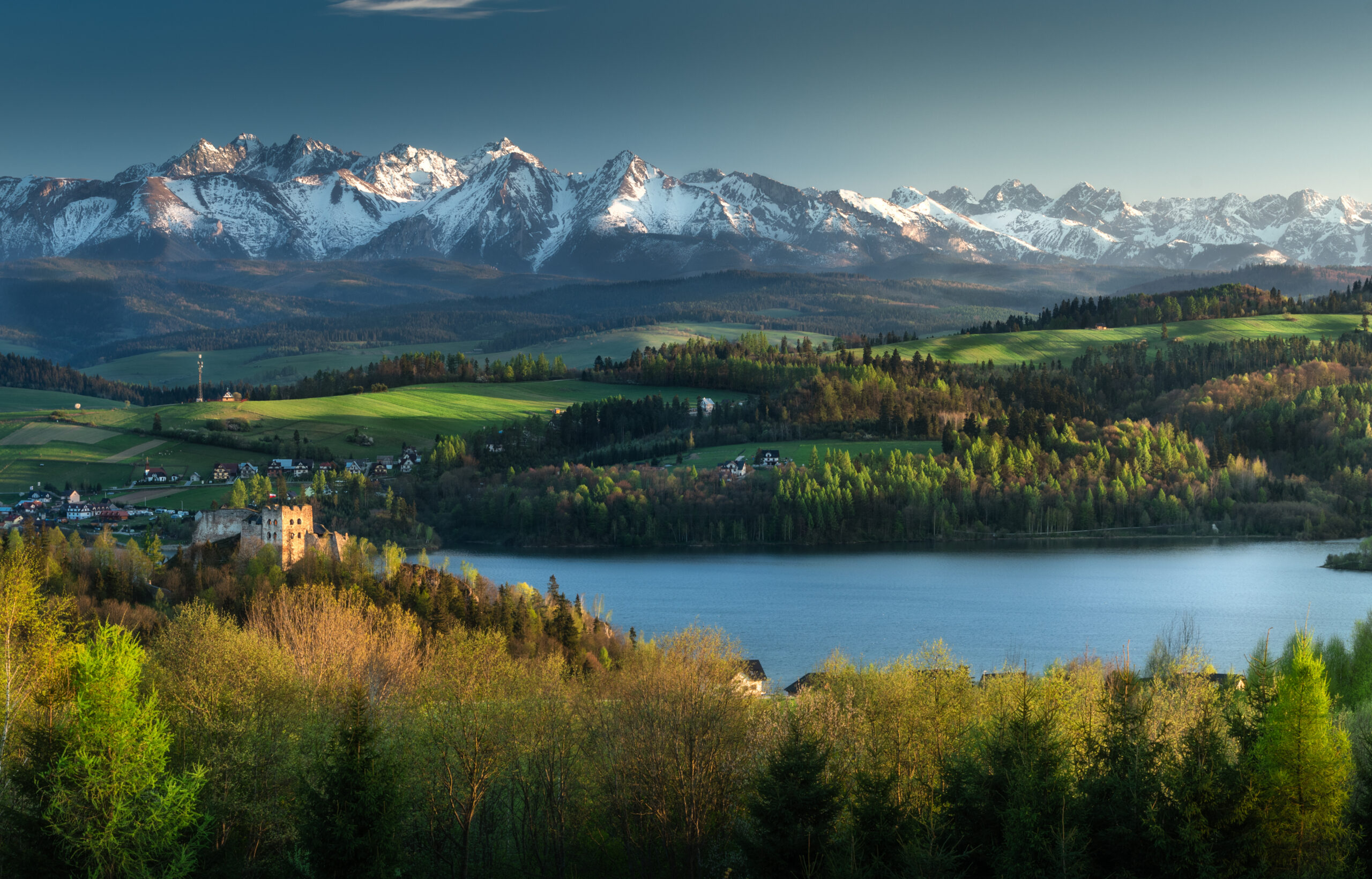 Panorama ośnieżonych Tatr nad Jeziorem Czorsztyńskim z zamkiem w Niedzicy